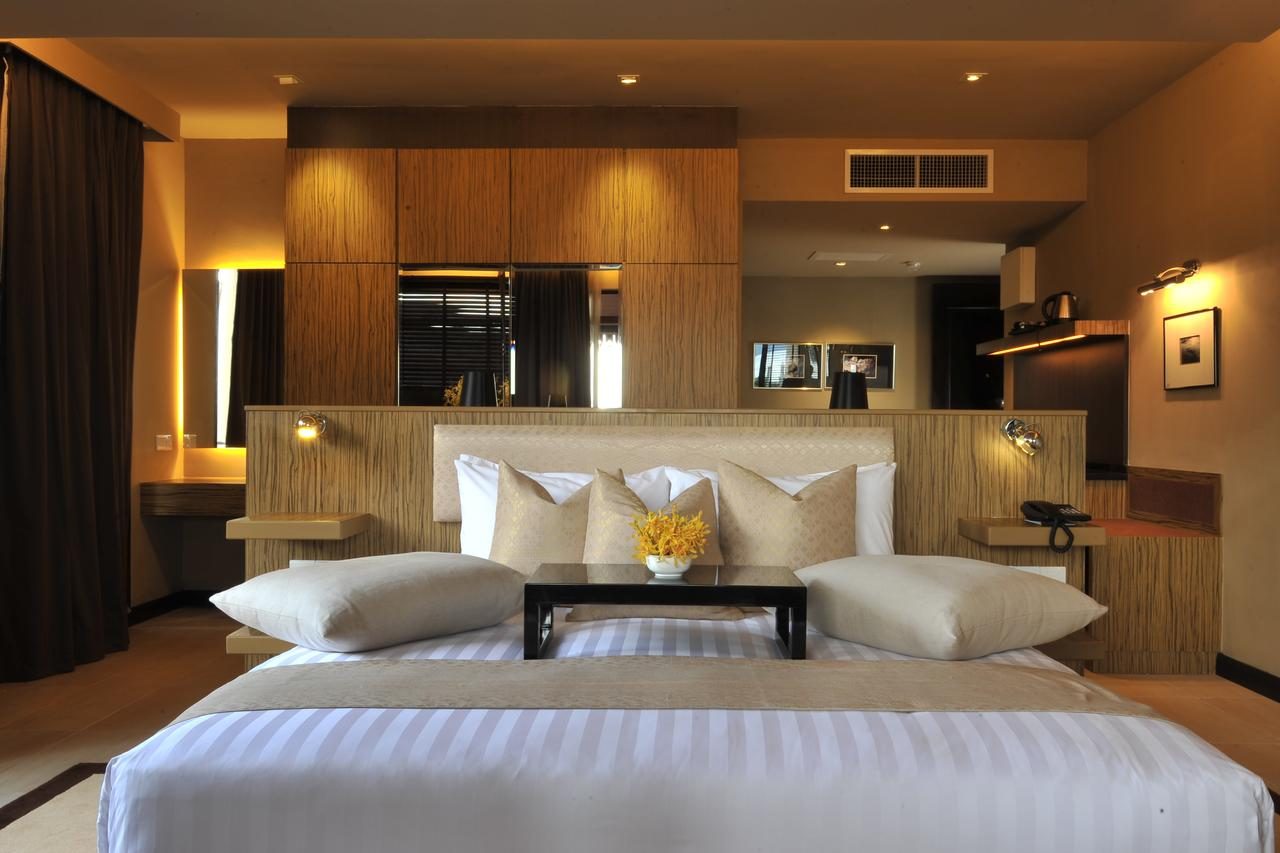 Hotel suite bed with dark wood headboard