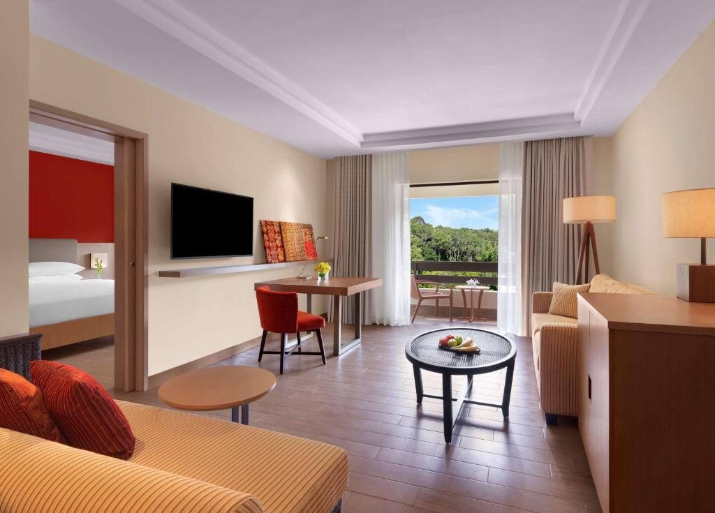 Hotel suite living area with red accent pillows